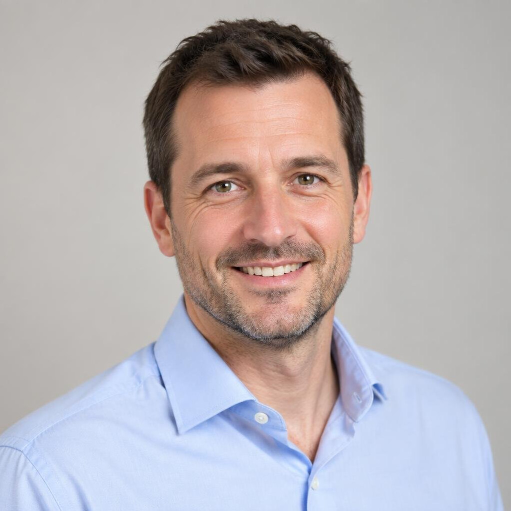 Portrait of a smiling man with short dark hair in a casual shirt